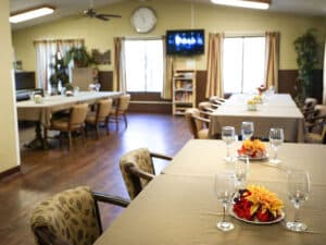 Dining tables set with tablecloths, fresh flowers and glasses.